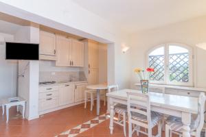 a kitchen and dining room with a table and chairs at La Terrazza sul Mare in Liscia di Vacca +19 photos