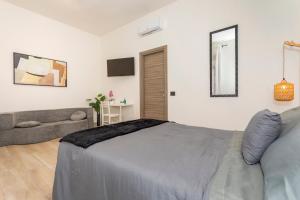 a bedroom with a bed and a couch at MSuite Etna Sicily in Macchia