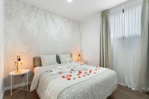 a bedroom with a white bed with flowers on it at Casa Llano del Rey in Arona +24 photos