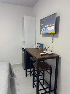 a room with a desk with a tv on the wall at HOTEl LIRIOS DEL MAR in Santo Domingo