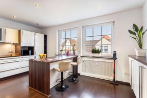 a kitchen with white cabinets and a counter with chairs at Exklusives Loft mit Kamin in Bad Salzuflen