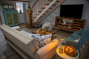 a living room with a couch and a tv at Villa Jerusalém - Casa de Campo in Romeu