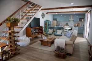 a living room with a staircase and a kitchen at Villa Jerusalém - Casa de Campo in Romeu