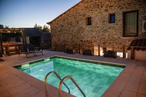 a swimming pool in front of a stone building at Villa Jerusalém - Casa de Campo in Romeu