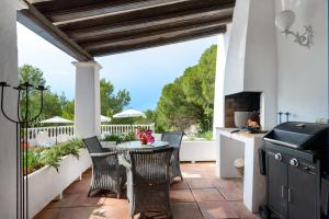 a patio with a table and chairs and a grill at Villa Renate in Sant Josep de sa Talaia