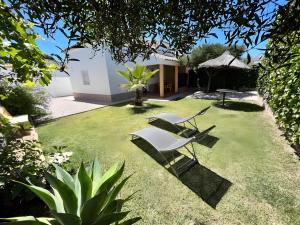 a yard with two chairs and a house at Casas Pepe 5 Bungalow in Los Caños de Meca