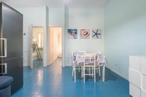 a dining room with a table and a blue tile floor at Da doddo e beby in Santa Margherita di Pula