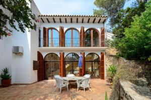 a patio with a table and chairs in front of a house at Villa Renate in Sant Josep de sa Talaia