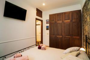 a bedroom with a bed with a television on the wall at Casa Carly Taormina in Taormina