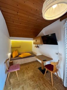 a small room with a bed and a table and chairs at Residence Zirmer in Castelrotto