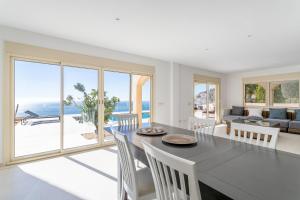 a dining room with a table and chairs and a view of the ocean at Villa Mina - First Line Villa in El Campello