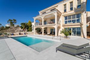a large house with a swimming pool in front of it at Villa Mina - First Line Villa in El Campello