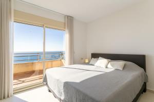 a bedroom with a large bed and a large window at Villa Mina - First Line Villa in El Campello +22 photos