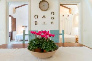 a vase with pink flowers on a table in a room at Villa Riggia - La Masseria in Nardò