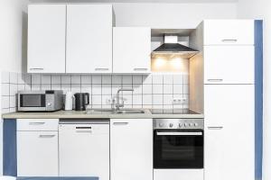 a white kitchen with white cabinets and a sink at Angie's Ferienapartment Thermalbad in Bad Staffelstein