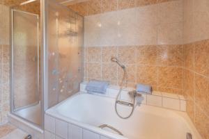 a bathroom with a bath tub and a shower at Fewo unterm Dreifaltigkeitsberg in Balgheim +19 photos
