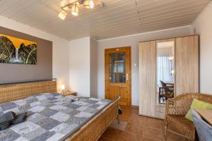 a bedroom with a large bed and a chair at Fewo unterm Dreifaltigkeitsberg in Balgheim