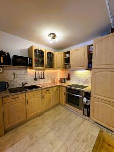 a large kitchen with wooden cabinets and appliances at Ferienwohnung Neubert in Eibenstock