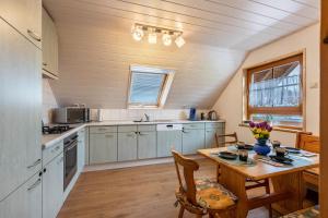 a kitchen with a wooden table and a dining room at Fewo unterm Dreifaltigkeitsberg in Balgheim
