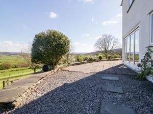 a stone walkway next to a white building at Barn Howe in Kendal