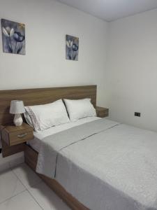 a bedroom with a bed and a table with a lamp at HOTEl LIRIOS DEL MAR in Santo Domingo