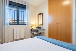 a bedroom with a bed and a desk and a window at Casa Emi in Cambrils +28 photos