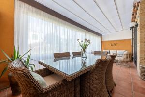 a dining room with a glass table and wicker chairs at Casa Emi in Cambrils