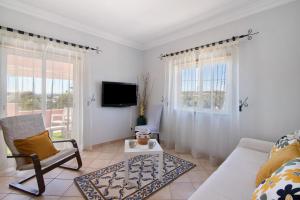 a living room with a couch and a tv at J R Dream house in Quarteira