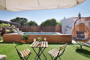 a backyard with a table and chairs and a swimming pool at J R Dream house in Quarteira