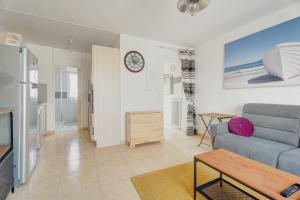 a living room with a couch and a table at Le Saint Martin Duplexe à la Mer in Bréhal