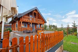a wooden house with a fence in front of it at Holzhaus Mühlenblick mit Whirlpool in Medebach