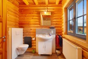 a bathroom with a sink and a toilet in a log cabin at Holzhaus Mühlenblick mit Whirlpool in Medebach +23 photos