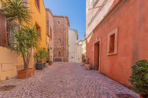 an alley in an old town with palm trees and buildings at Maison de ville Fréjus in Fréjus