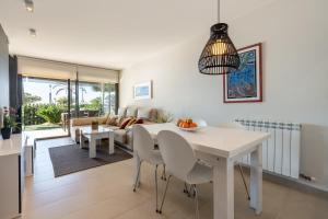 a dining room and living room with a white table and chairs at Apartamento Ballena in Cambrils