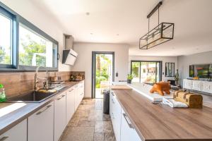 a kitchen with white cabinets and a wooden counter top at Eden Balinais in Le Muy