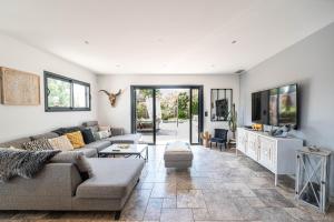a living room with a couch and a tv at Eden Balinais in Le Muy