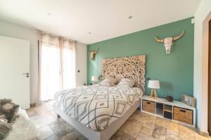 a bedroom with a large bed and a blue wall at Eden Balinais in Le Muy +35 photos