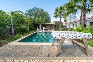 a pool with a ping pong table in front of a house at Eden Balinais in Le Muy