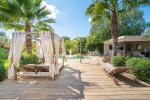 a couple of hammocks on a deck with palm trees at Eden Balinais in Le Muy