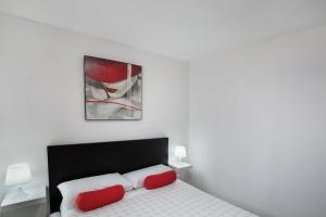a bedroom with a bed with two red pillows at Villa Monica B in Agüimes