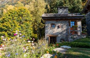 a stone house in the middle of a garden at Chalet Panorama Res Albert in San Guglielmo +22 photos