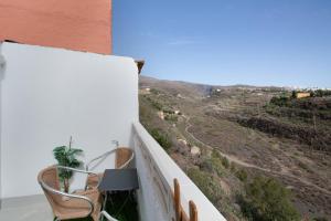a balcony with chairs and a view of a mountain at Villa Monica B in Agüimes