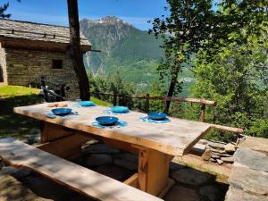 a wooden table with blue bowls on top of it at Chalet Panorama Res Albert in San Guglielmo