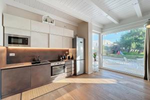 a kitchen with stainless steel appliances and a large window at Villa Traimari in Trani