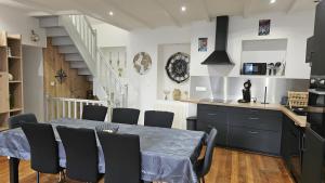 a kitchen and dining room with a table and chairs at gite in Saint-Vaast-la-Hougue +4 photos