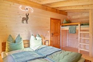a bedroom with a bed in a log cabin at Haus Glückswiese in Großhartberg
