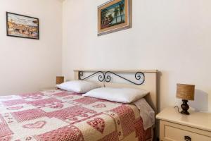 a bedroom with a bed with a quilt on it at Appartamento Al Sasso Rosso Dimaro in Dimaro