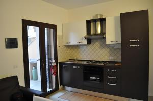 a kitchen with a black stove top oven next to a door at Casa vacanza La Rosa dei Venti in Viddalba