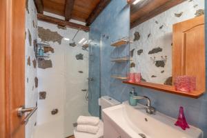 a bathroom with a toilet and a sink and a shower at Finca El Tablero in Tinajo +24 photos