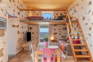 a room with a bunk bed and a table and chairs at Finca El Tablero in Tinajo